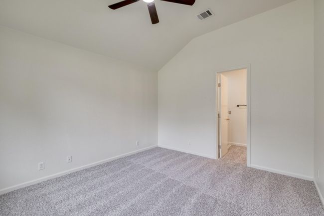 Empty room featuring a ceiling fan, carpet floors, and vaulted ceiling | Image 15