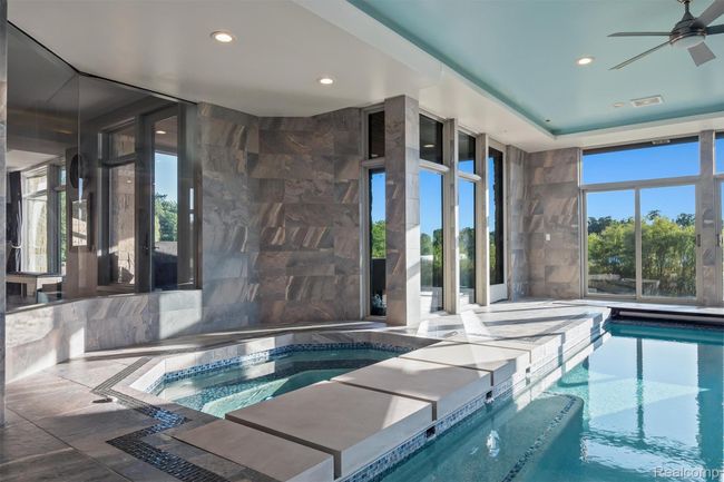Indoor pool with a hot tub and a ceiling fan | Image 30