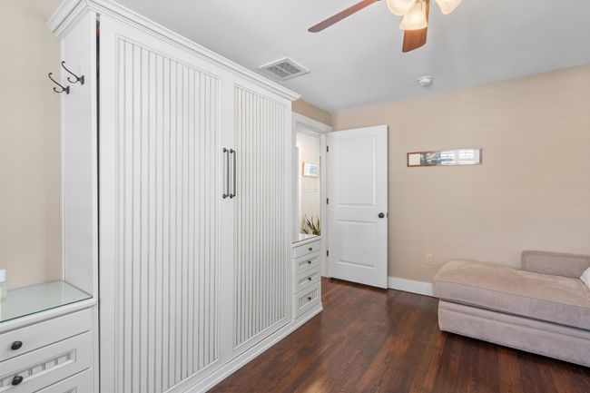 Living area with a ceiling fan, dark wood finished floors, baseboards, and visible vents | Image 19