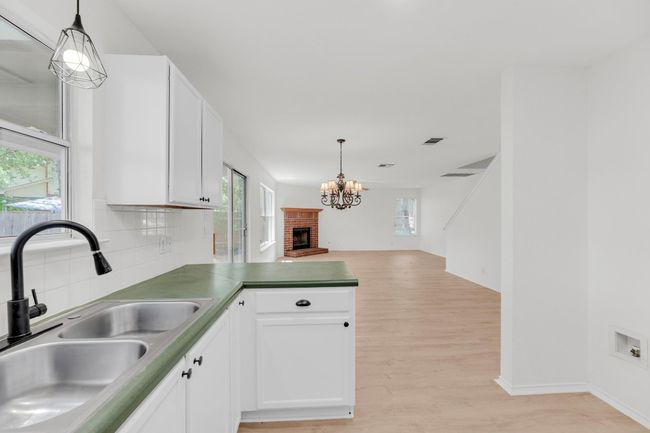 Kitchen with tasteful backsplash, a wealth of natural light, light wood finished floors, and a sink | Image 13