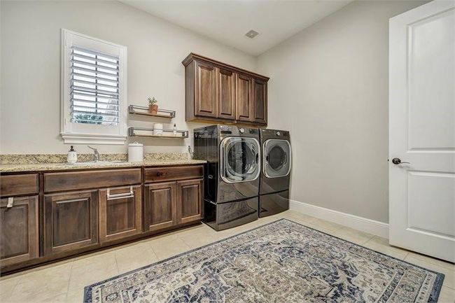 Spacious laundry room with ample storage and a large utility sink. | Image 22