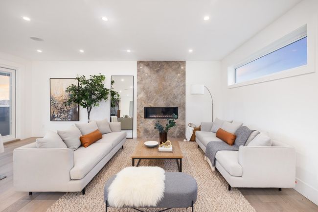 Living area with recessed lighting, a tile fireplace, and light wood-type flooring | Image 4