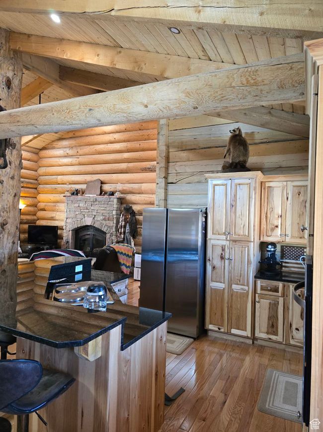 Kitchen featuring light wood finished floors, wood ceiling, log walls, and freestanding refrigerator | Image 56