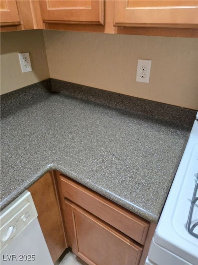 Interior details with dark countertops and brown cabinets | Image 9