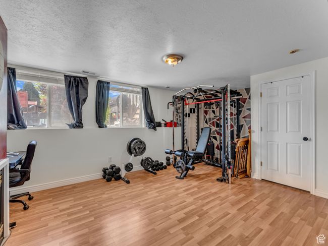 Workout area featuring wood finished floors, healthy amount of natural light, a textured ceiling, and baseboards | Image 20