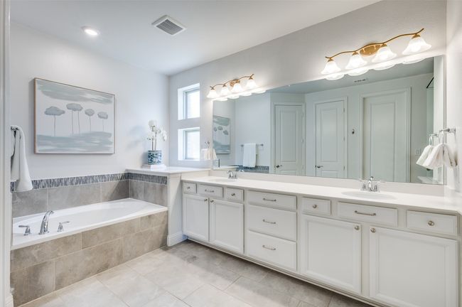 En suite primary bath is the perfect escape to wind down in the evening with soaker tub, large wall length mirror, double sinks and fogged windows for natural lighting. | Image 19