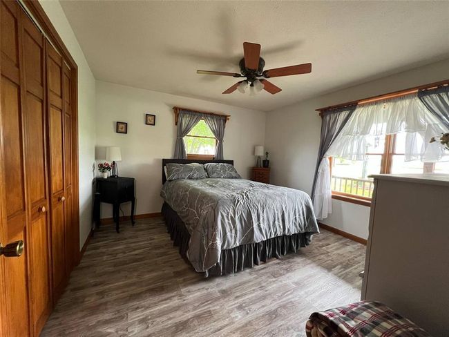 Bedroom with wood finished floors, baseboards, a closet, and ceiling fan | Image 7