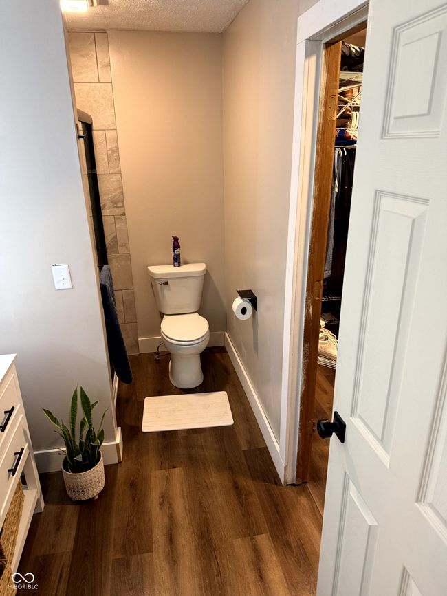 bathroom with wood finished floors, toilet, a shower, baseboards, and vanity | Image 28