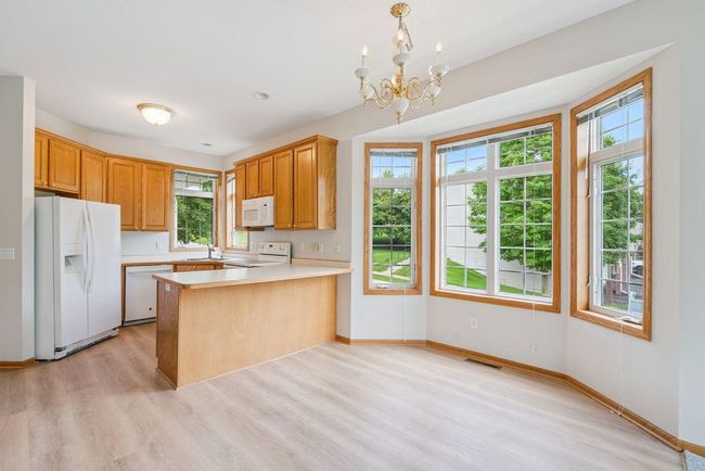 Informal dining area & kitchen with new luxury vinyl plank flooring, light & bright bay window. Kitchen has 42" custom oak cabinets. | Image 4