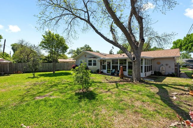 Rear view of property with a yard, a fenced backyard, and a sunroom | Image 24