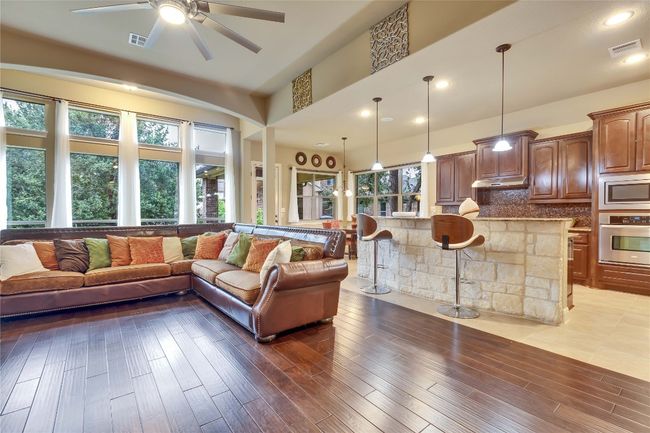 Living room featuring a ceiling fan, hardwood finished floors, recessed lighting, and lofted ceiling | Image 25