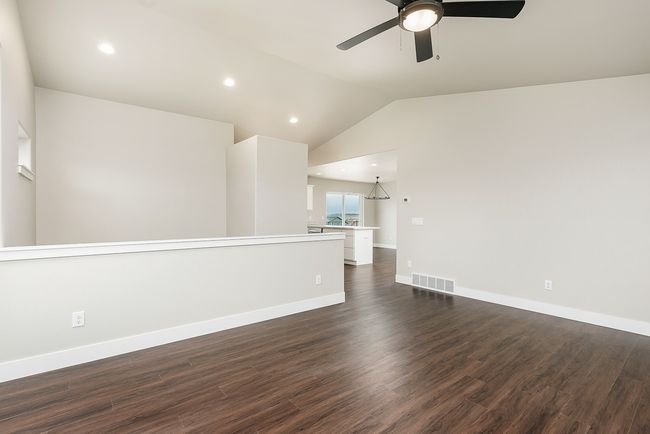 Unfurnished room with visible vents, ceiling fan, baseboards, lofted ceiling, and dark wood-style floors | Image 5