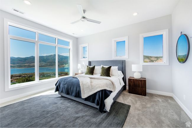 Carpeted bedroom with ceiling fan and a water and mountain view | Image 10