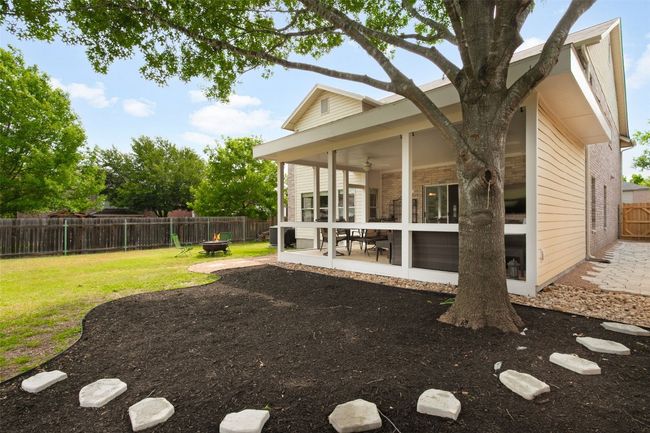 Discover the perfect backyard oasis! This stunning home features a charming covered patio area, ideal for outdoor gatherings and relaxation. Enjoy the refreshing shade provided by a majestic oak tree, making this space your go-to retreat. Don’t miss the chance to make this serene outdoor haven your own!Rear view of house with a patio, brick siding, a sunroom, central air condition unit, and ceiling fan | Image 36