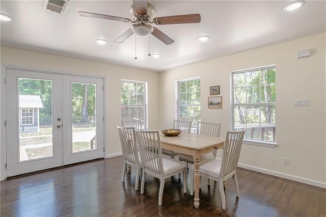 Dining area featuring dark wood-type flooring, ceiling fan, and french doors | Image 20