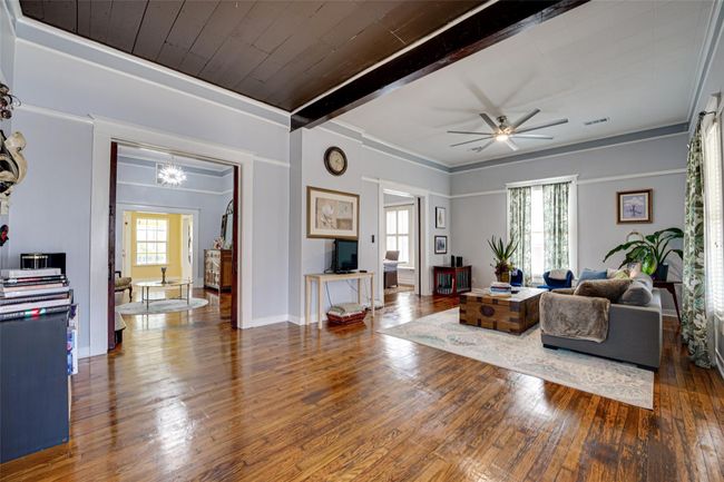Living area featuring beamed ceiling, hardwood / wood-style floors, visible vents, and a ceiling fan | Image 6