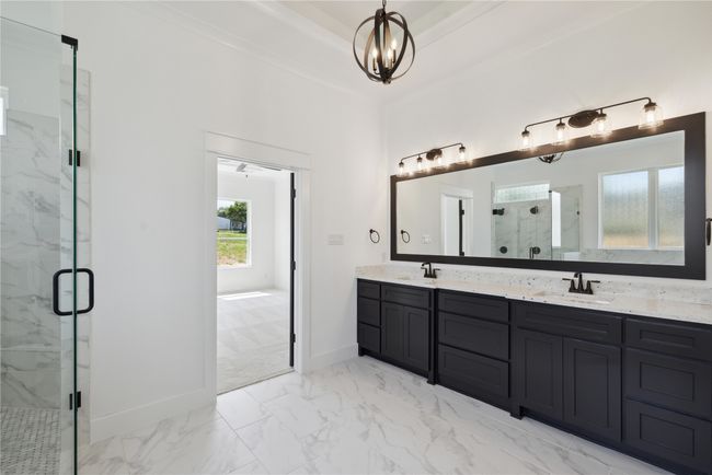 Bathroom featuring vanity, a notable chandelier, a raised ceiling, and walk in shower | Image 32