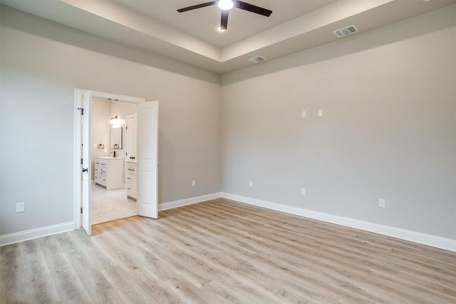 Empty room with visible vents, a ceiling fan, light wood-style floors, and baseboards | Image 17