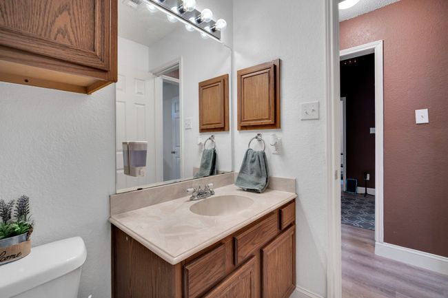 Half bath with vanity, wood finished floors, and a textured wall | Image 24