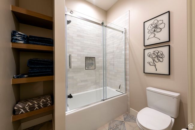 Full bath with enclosed tub / shower combo and tile patterned floors | Image 52