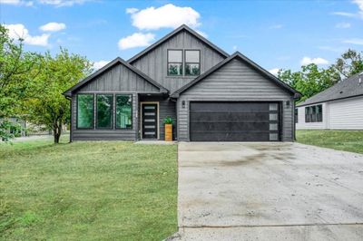 View of front facade with a garage and a front yard | Image 2