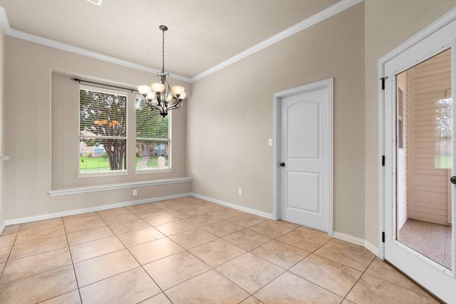 Dining / breakfast area with light tile patterned floors, crown molding, and a nice light fixture | Image 13
