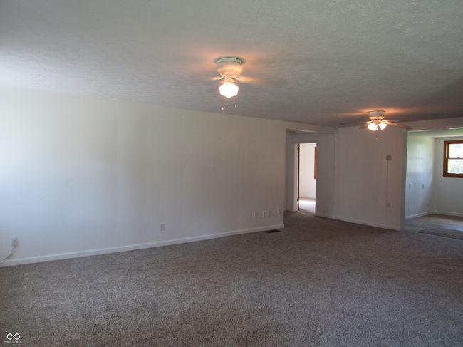 Living room featuring a ceiling fan, carpet flooring, and a textured ceiling | Image 12
