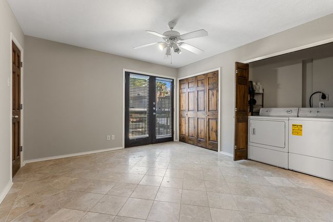 Washroom featuring laundry area, ceiling fan, light tile patterned floors, baseboards, and washer and clothes dryer | Image 19