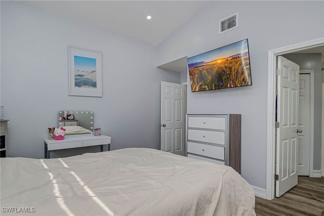 Bedroom featuring dark wood-type flooring, vaulted ceiling, and baseboards | Image 10