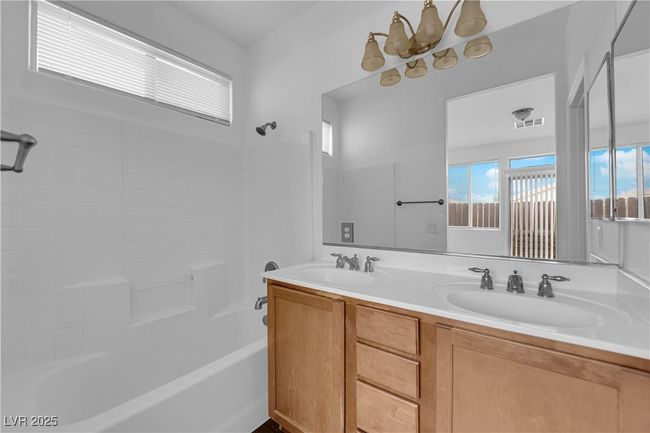 Bathroom with shower / bathtub combination, a sink, visible vents, and double vanity | Image 11