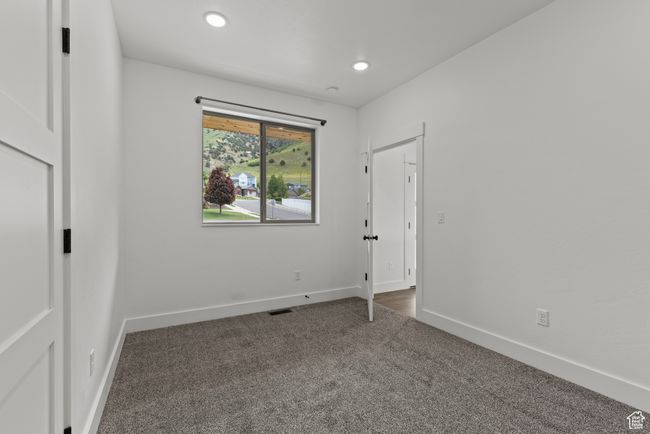 Unfurnished bedroom featuring dark carpet, baseboards, and recessed lighting | Image 25