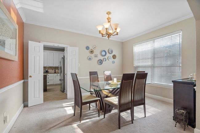 Dining room featuring a chandelier, light carpet, and crown molding | Image 10