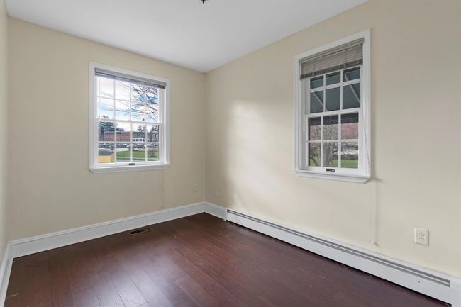 Unfurnished room featuring a baseboard radiator, dark wood-type flooring, and baseboards | Image 31