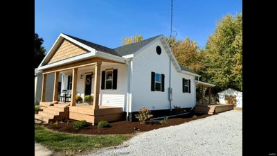 View of property exterior with a porch, a garage, and an outdoor structure | Image 3