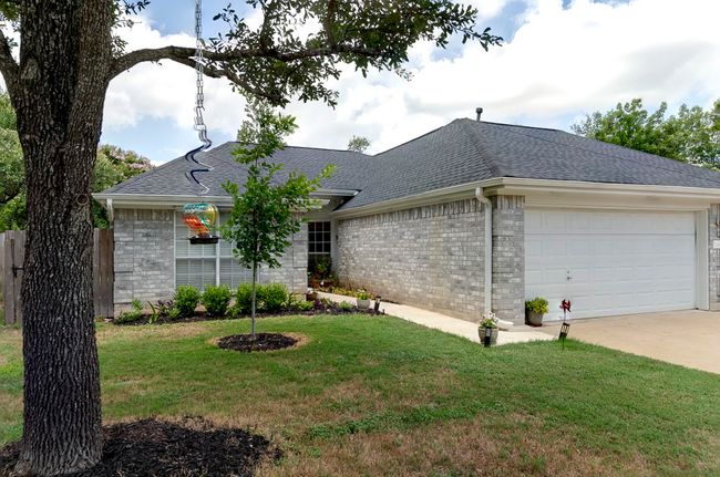 View of front of property featuring a shingled roof, a garage, a front yard, concrete driveway, and brick siding | Image 20