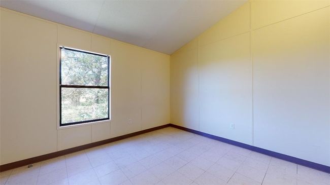 Unfurnished room featuring plenty of natural light, lofted ceiling, and light floors | Image 48