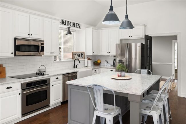 Another view of the kitchen - ample seating for all - stainless appliances, lots of natural light. | Image 6