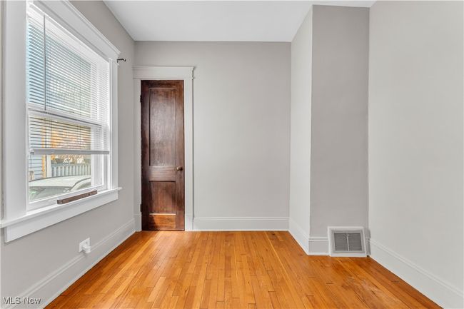 Empty room with visible vents, baseboards, and light wood-style floors | Image 17