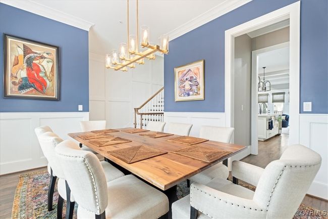Dining space featuring wood finished floors, a chandelier, and a decorative wall | Image 19