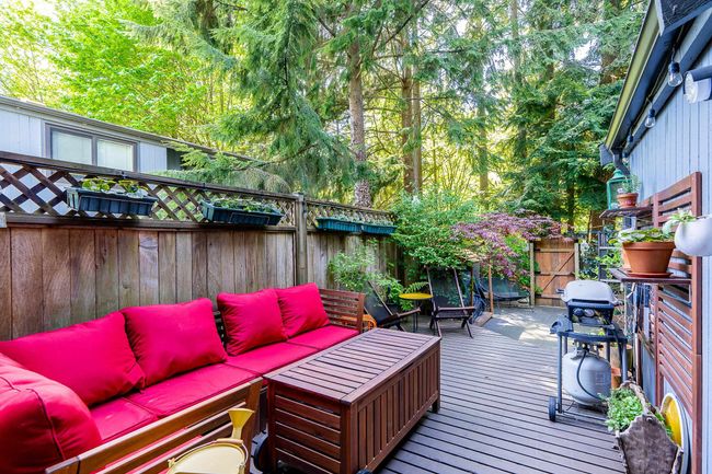 Deck with outdoor lounge area, a fenced backyard, and a grill | Image 21
