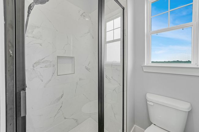 Bathroom with toilet and a marble finish shower | Image 18