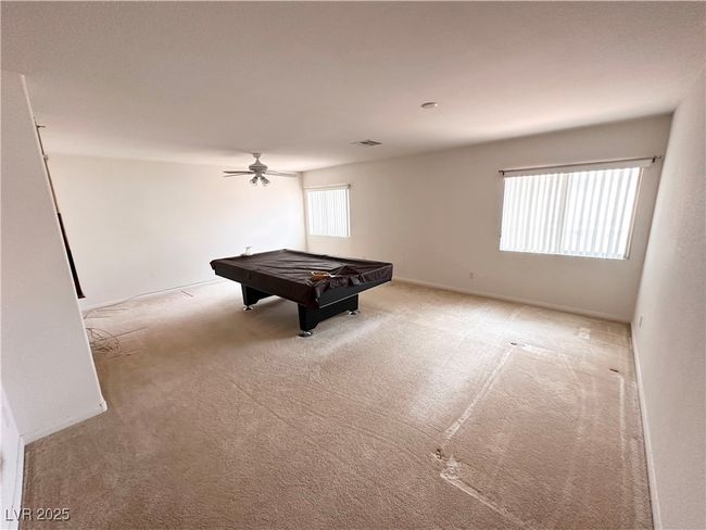 Recreation room with carpet floors, pool table, a ceiling fan, and baseboards | Image 19