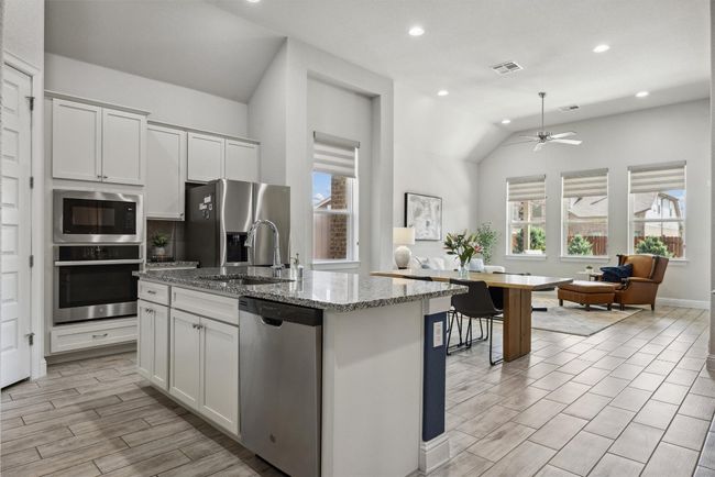 Kitchen featuring stainless steel appliances, healthy amount of natural light, vaulted ceiling, granite counters and oversized pantry | Image 6