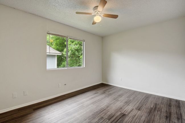 Spare room featuring wood finished floors, ceiling fan, a textured ceiling, and baseboards | Image 12