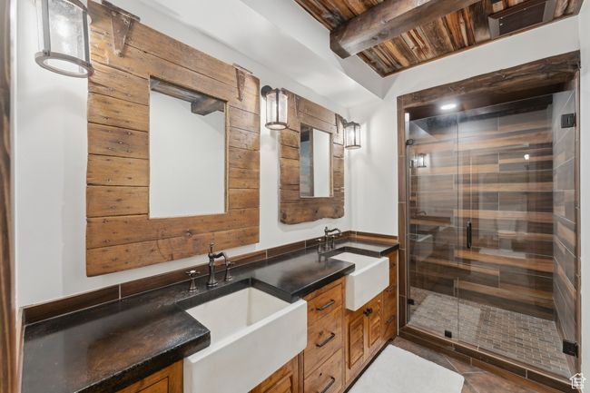 Full bathroom featuring double vanity, a relaxing sauna, a stall shower, a wooden ceiling with exposed beams, and tile patterned flooring | Image 43