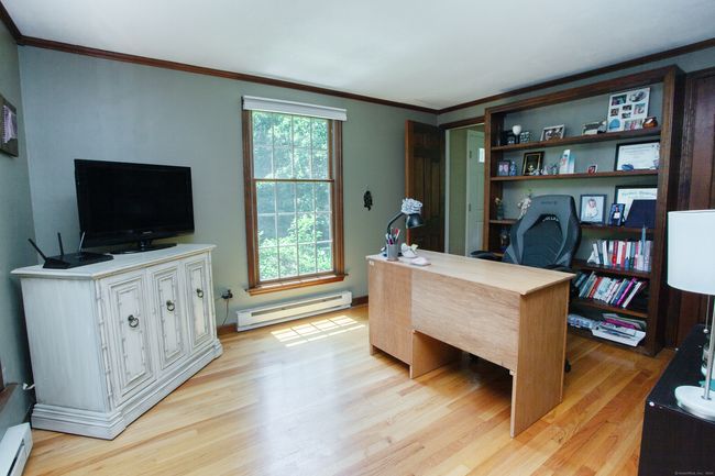 First floor bedroom with full bath is being used as a home office with hardwood floors and built-ins | Image 19