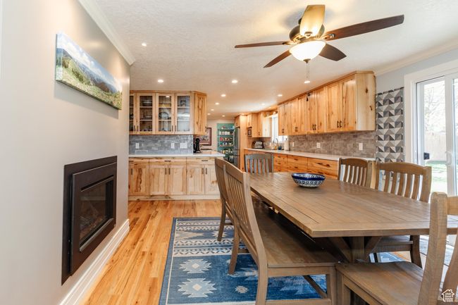 Dining space with recessed lighting, a glass covered fireplace, crown molding, and a ceiling fan | Image 5
