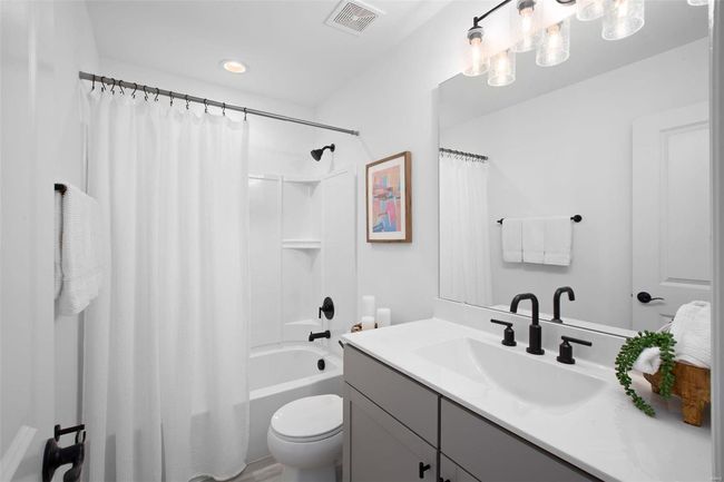 Full bathroom featuring shower / tub combo with curtain, vanity, and toilet | Image 21