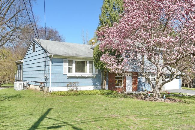 View of front of house with concrete driveway, an attached garage, and a front yard | Image 31