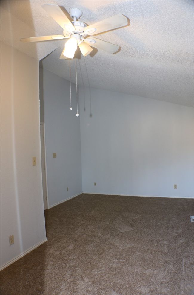 Carpeted empty room with a textured ceiling and ceiling fan | Image 22